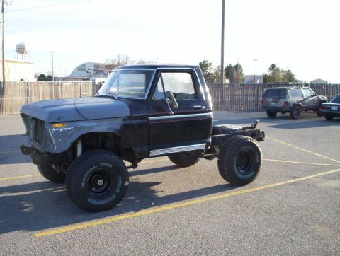 1978 Ford Bronco - This pickup truck chassis with a cab is missing its front end and appears to be undergoing modification.