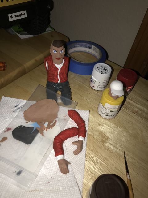 1989 Ford Bronco - Crafting supplies, including toy figure parts and paint, are laid out on a table for a hobby project.