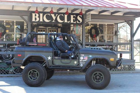 1972 Ford Bronco - This heavily modified 1972 Ford Bronco is parked outside a bicycle shop, ready for adventure.