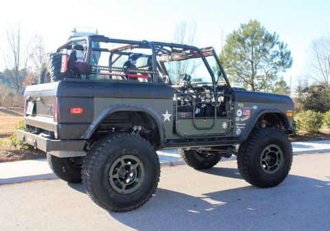 1972 Ford Bronco - Modified Ford Bronco with a custom roll cage and off-road tires is parked on a paved surface.