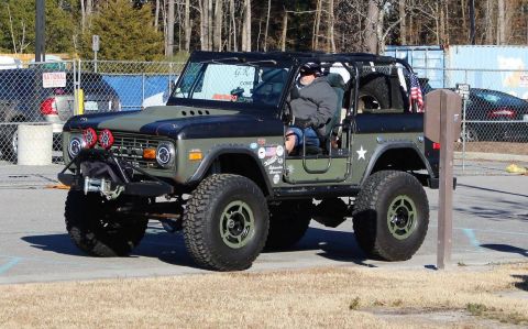 1972 Ford Bronco - Modified 1972 Ford Bronco with aftermarket bumper and lights, seen from the front-3/4 view.
