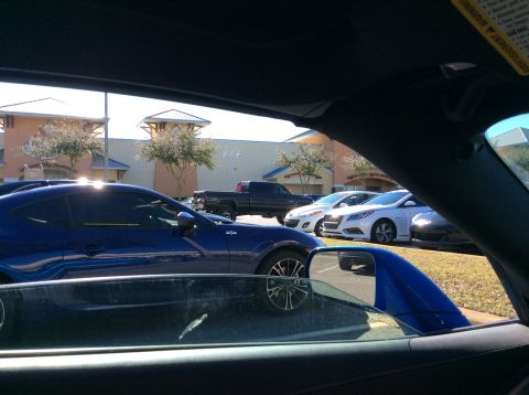 1992 Ford Bronco - A blue coupe is parked in a lot with several other vehicles visible in the background.