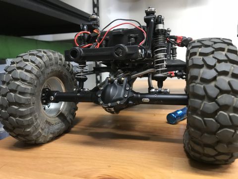 1989 Ford Bronco - Close-up view of the suspension and drivetrain of a remote control rock crawler chassis.