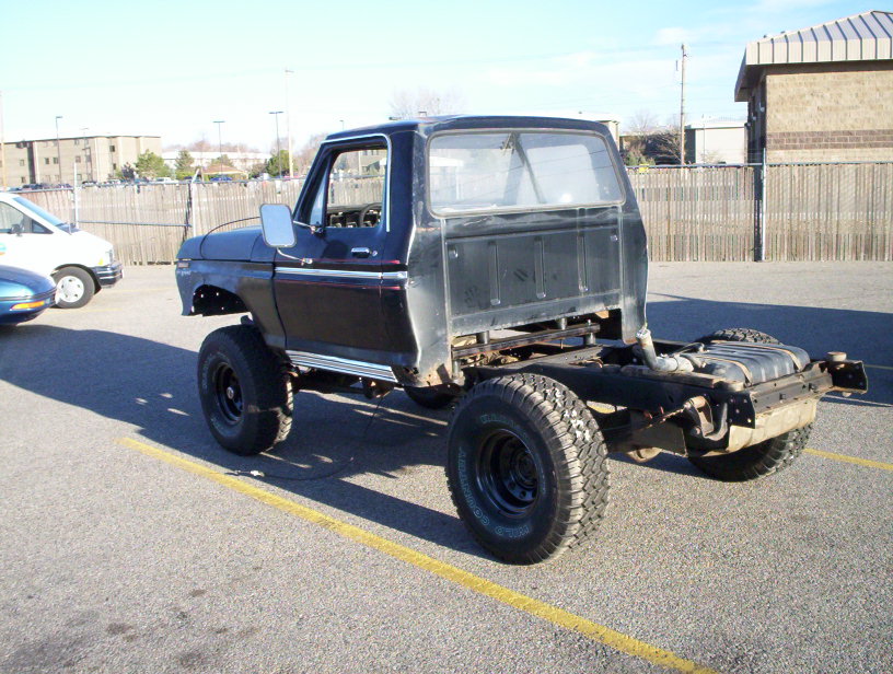 Black Ford F-Series truck chassis with lifted suspension and large tires, viewed from the front 3/4 angle