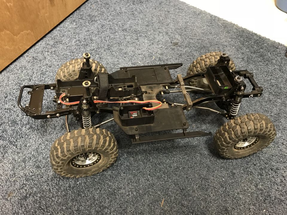 Remote control car chassis with large tires and suspension components, viewed from a high angle