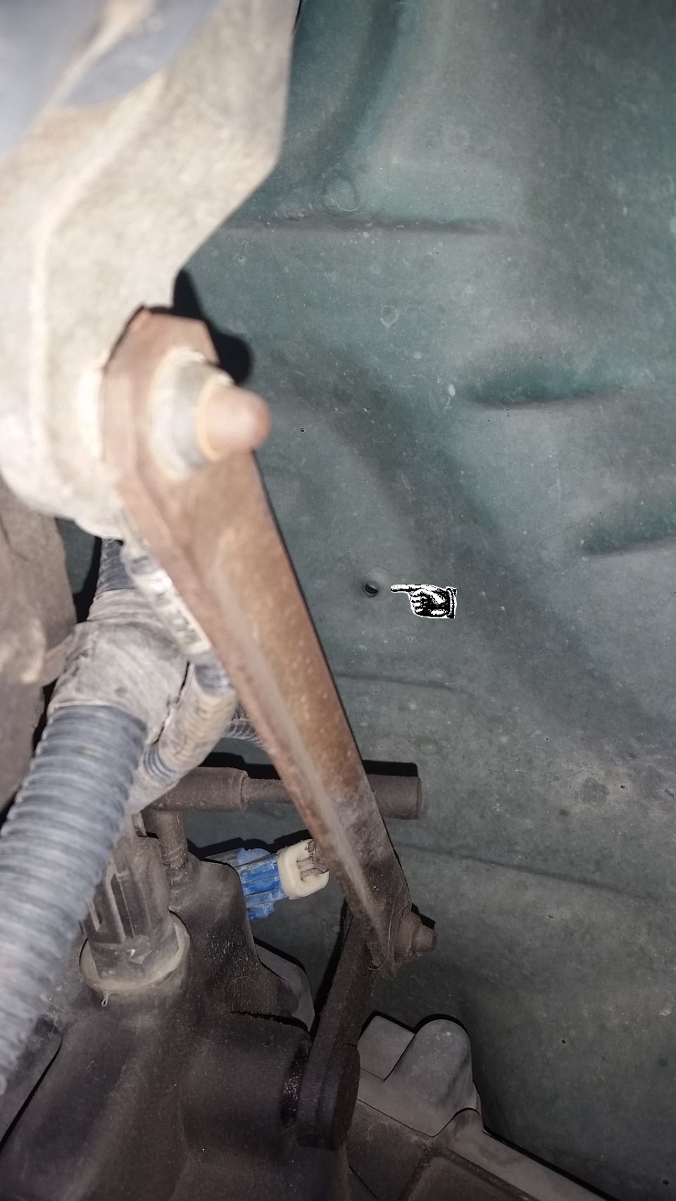 Looking up from underneath the truck, on the driver's side we can see that Ford has already punched a hole in the body in order to mount the center console.  There is another hole on the passenger side, and one centered between the two a little further back.