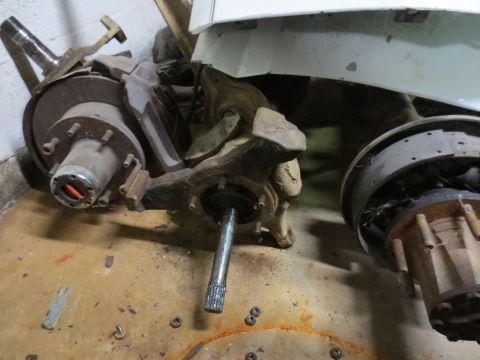 1967 Ford F-250 - Various rusty truck suspension parts are piled on a concrete floor.