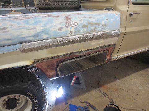 1967 Ford F-250 - The side of a 1967 Ford F-250 pickup truck undergoing body repair, showing welding and primer.