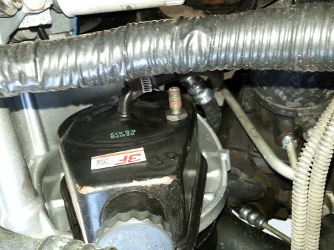 1994 Ford Bronco - Close-up view of a vehicle's power steering pump assembly, showing hoses and mounting hardware.