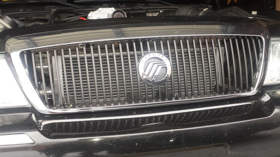 Black Mercury Grand Marquis front grille with chrome trim and Mercury emblem.