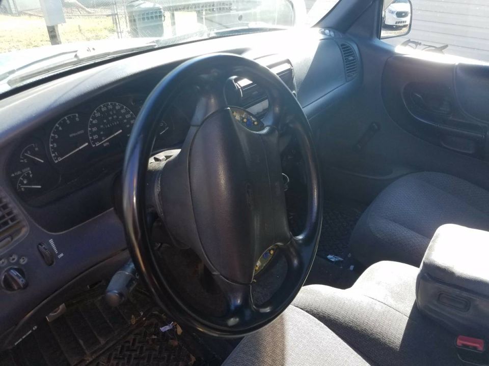 Interior of a 1998 Ford Ranger showing steering wheel, dashboard, and seats.