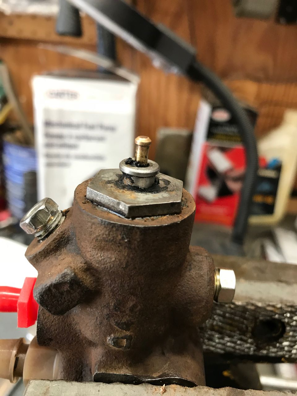 Close-up of a rusty brake master cylinder part with a brass fitting.