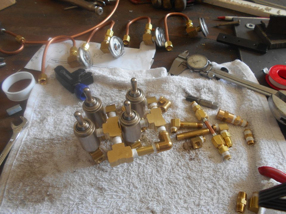 Brass pneumatic fittings and copper tubing on a towel.