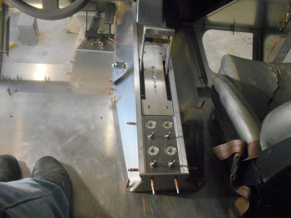 Vehicle interior showing floor, center console with shifter and switches, and part of a seat.