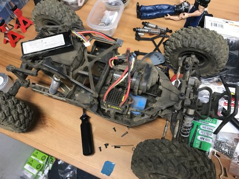 1989 Ford Bronco - The disassembled chassis of a remote control car, showing its internal components and wiring, sits on a workbench.