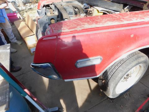 1968 Mercury Cougar - A red 1968 Mercury Cougar is partially visible, with its front fender, tire, and engine bay in view.