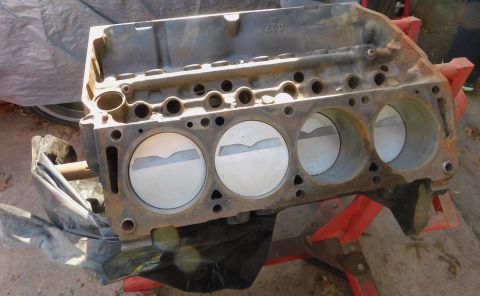 1968 Mercury Cougar - Engine block with pistons installed, supported by red stands. A casting number is visible on the block.