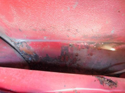 1968 Mercury Cougar - Rust and corrosion visible on red painted metal, indicating wear and tear.