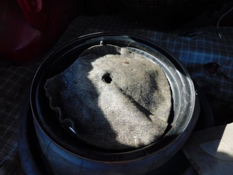 1968 Mercury Cougar - The spare tire well shows a gray mat with a hole, sitting inside a metal rim.