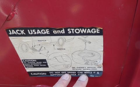 1968 Mercury Cougar - A sticker on a red car details proper jack usage and tire stowage procedures.