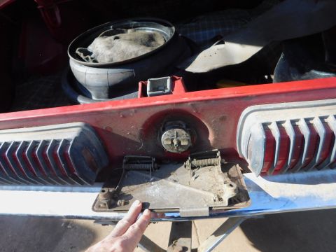 1968 Mercury Cougar - Close-up of a red car's rear bumper and taillight assembly, showing chrome trim and internal mechanisms.