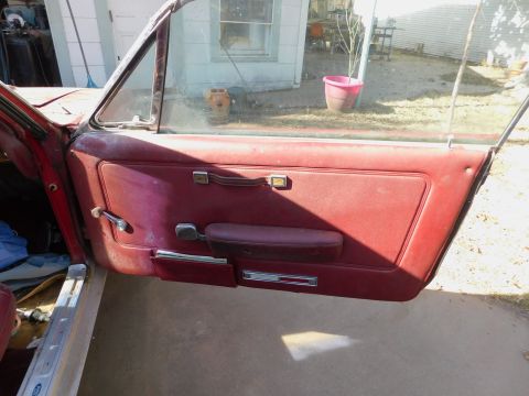 1968 Mercury Cougar - Interior view of a red car door with visible wear and tear.