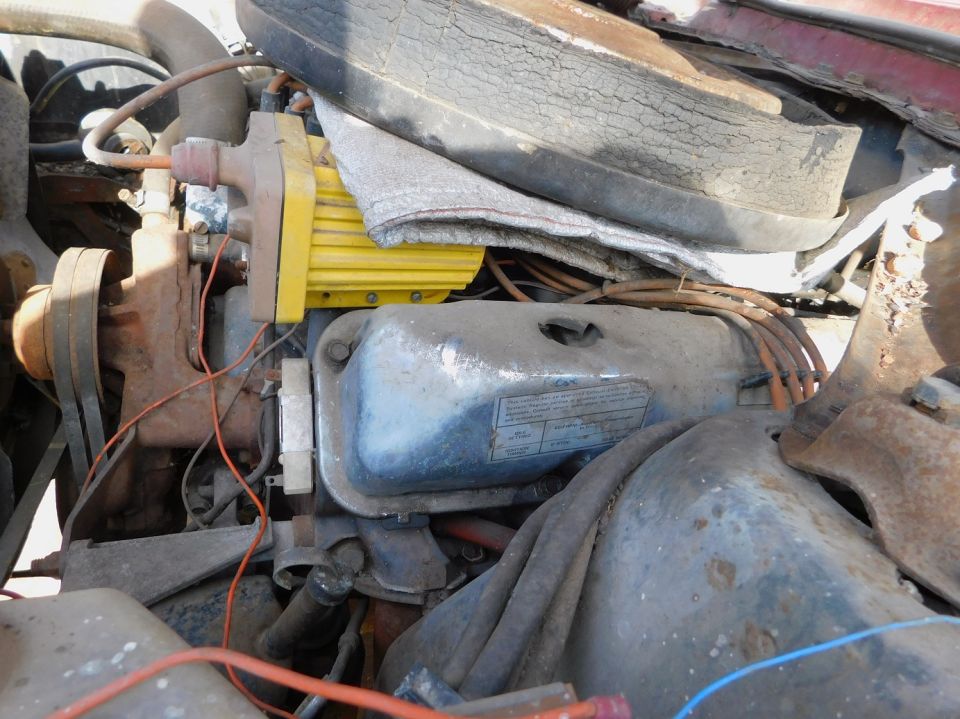 Engine bay with a yellow component and a tire visible