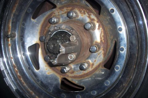 1973 Ford F-250 - This image shows a close-up view of a front wheel hub, visible rust and grease, with chrome lug nuts.