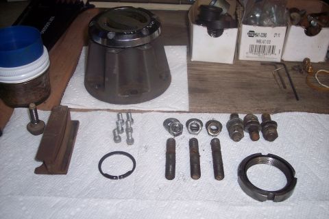1973 Ford F-250 - Various automotive parts, including a hub assembly and fasteners, are laid out on a surface.