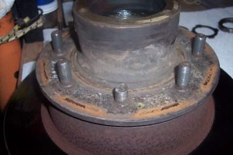 1973 Ford F-250 - This is a close-up of a rusty front wheel hub assembly, likely from a truck, with a brake rotor visible below.