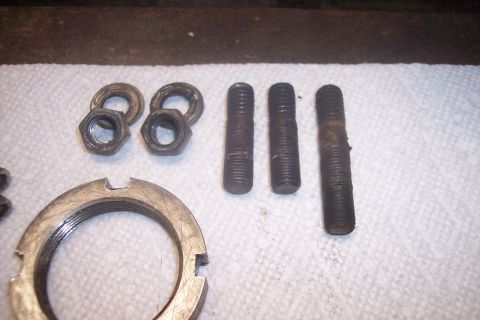 1973 Ford F-250 - Various hub nuts, washers, and bolts are displayed on a white cloth, likely for a vehicle repair or maintenance project.