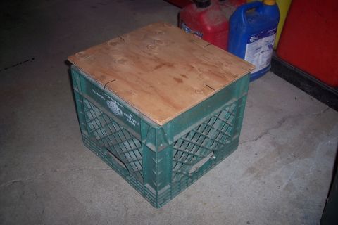 1995 Ford Bronco - A homemade stool constructed from a milk crate and a piece of plywood sits on a concrete floor.