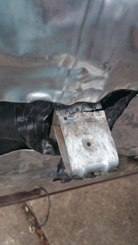1996 Ford Bronco - A metal bracket is welded to the vehicle's undercarriage, with a black-taped pipe nearby.