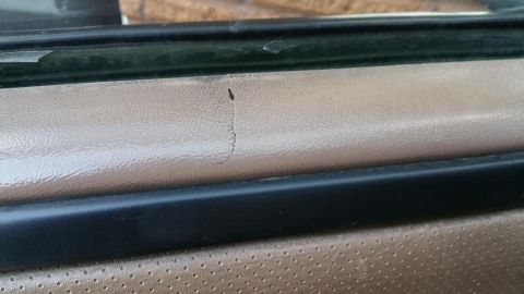 1996 Ford Bronco - Close-up of a cracked vinyl door panel inside a vehicle.