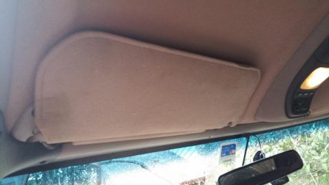 1996 Ford Bronco - View of the interior sun visor and overhead console with a lit interior light.