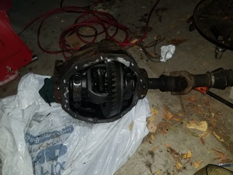 1995 Ford Bronco - A differential axle assembly is shown with its internal gears visible, placed on a white plastic bag on a concrete floor.
