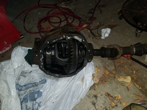 1995 Ford Bronco - A differential assembly, likely from a truck or SUV, is shown with its internal gears visible. It appears to be in a workshop or garage set…