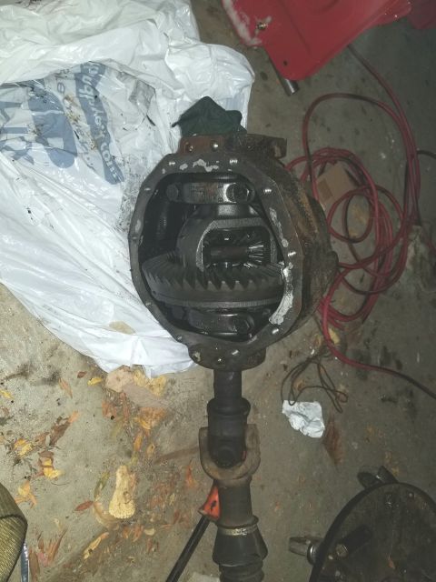 1995 Ford Bronco - Differential housing and driveshaft assembly shown on a concrete floor with some debris.