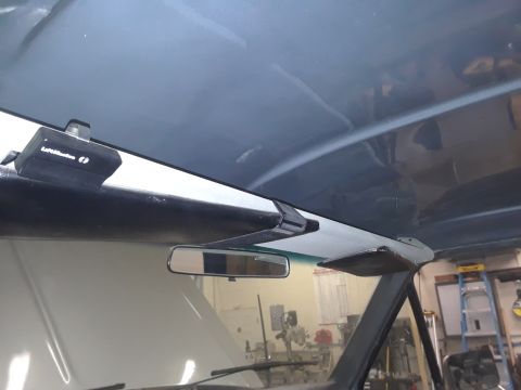 1985 Ford Bronco - Interior view of a vehicle's headliner, showing a garage door opener and rearview mirror.