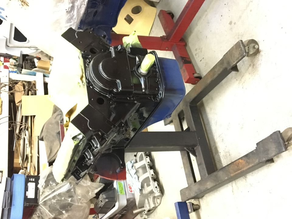 Black engine block on a stand with parts around it