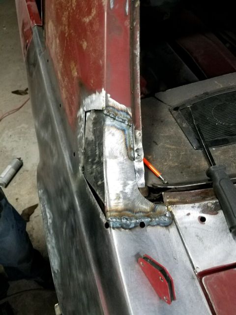 1968 Mercury Cougar - Close-up view of metal repair work being done on the rear quarter panel of a red vehicle.