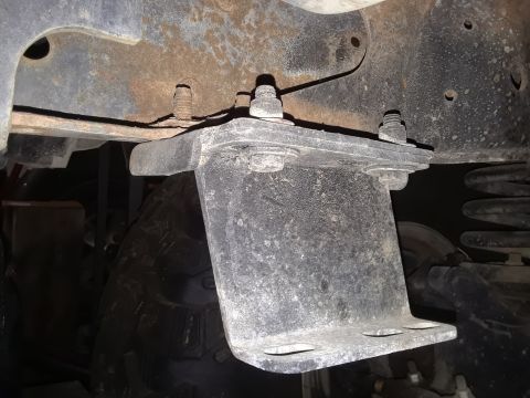 1985 Ford Bronco - Close-up view of a vehicle's undercarriage, showing a suspension bracket and tire.