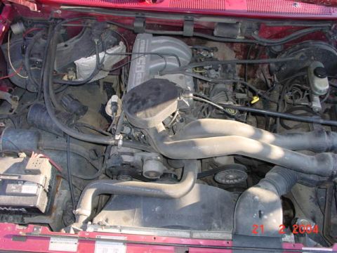 1992 Ford F-150 - The engine bay of a 1992 Ford F-150 is captured in this detailed photograph, highlighting various components.