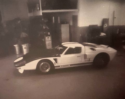 1973 Ford Mustang - A white Ford GT40 with a black hood and racing stripes is parked in a garage.