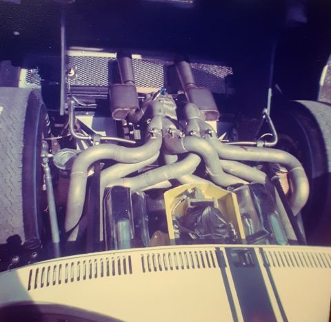 1973 Ford Mustang - This image shows the engine bay of a vehicle, a custom exhaust system with prominent headers and dual mufflers.