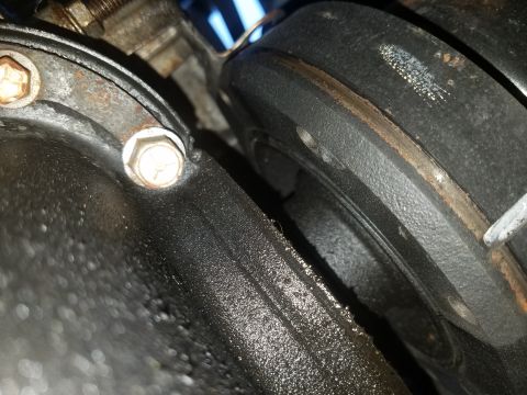 1994 Ford Bronco - Photograph of an oily engine part with a bolt, not a technical document.