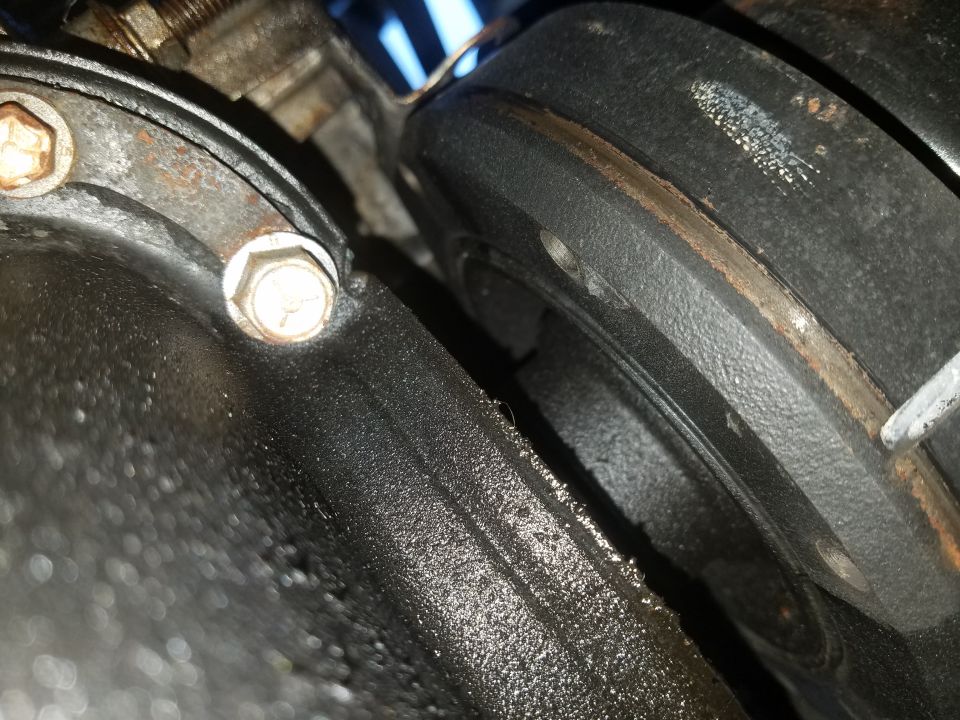 Close-up photo of a greasy engine component and bolt