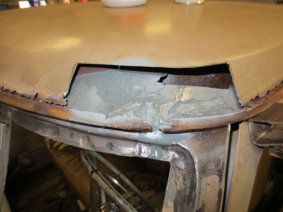 Close-up of rusted and repaired metal panel on a vehicle.