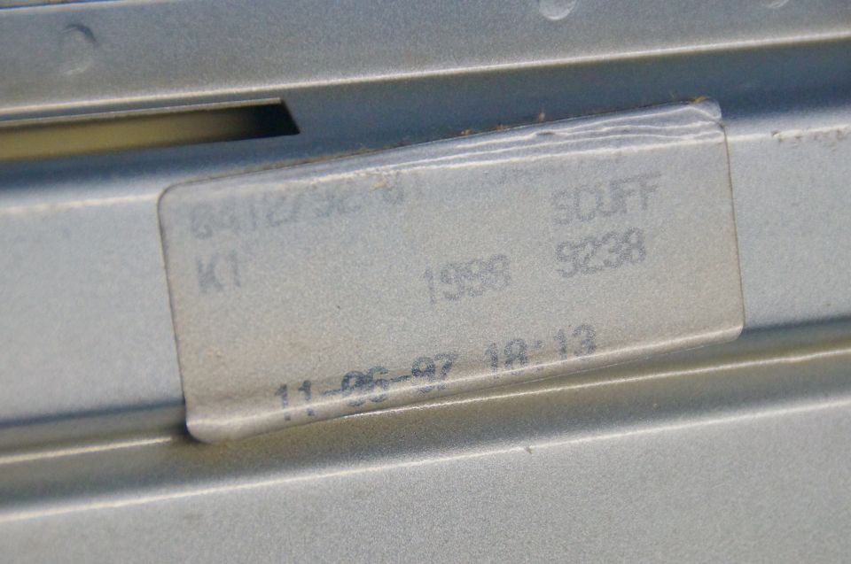 Close-up of a manufacturing inspection label inside a metal panel reading SCUFF