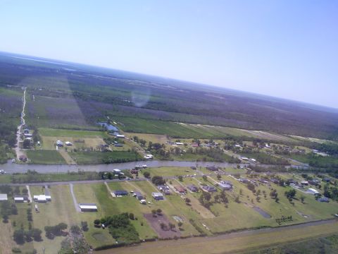 1992 Ford Bronco - An aerial view shows a rural landscape with a winding river, scattered houses, and extensive fields under a clear blue sky.